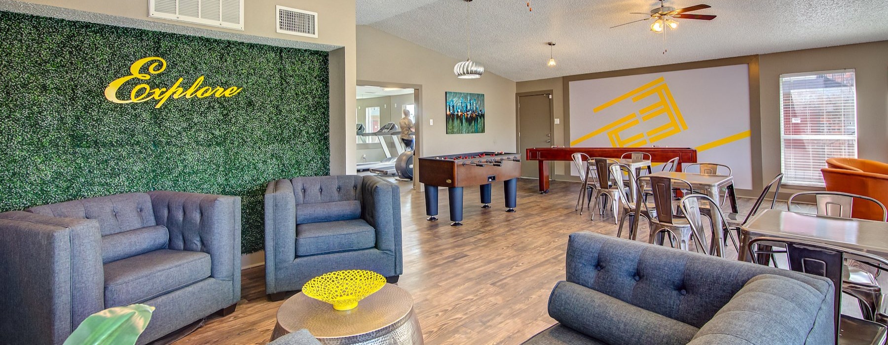 a clubroom with a couch, tables and chairs